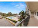 Relaxing balcony view overlooking a sparkling pool, lush landscaping, a marina, and picturesque waterway at 8141 Aquila St # 322, Port Richey, FL 34668