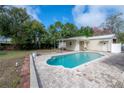 Backyard featuring a refreshing in-ground pool, a covered patio, and a detached garage at 9618 N 55Th St, Temple Terrace, FL 33617