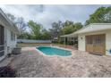 The in-ground pool features a brick pool deck and the backyard is surrounded by lush landscaping at 9618 N 55Th St, Temple Terrace, FL 33617