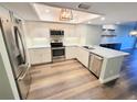 Modern kitchen featuring stainless steel appliances, white cabinets and a stylish backsplash at 9914 Indian Key Trl # 32, Seminole, FL 33776