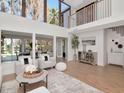 Open-concept living room with plenty of natural light, hardwood floors, and a view of the second-story balcony at 17009 Paula Ln, Lutz, FL 33558