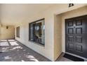 Welcoming entrance of a condo featuring a black door with a covered porch and tiled floor at 1801 E Lake Rd # 5H, Palm Harbor, FL 34685