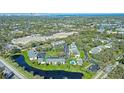 Aerial view of condo community featuring lush landscaping, a pool, and a beautiful pond at 3001 58Th S Ave # 312, St Petersburg, FL 33712