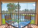 Serene screened balcony with table and chairs offers views of the lake and swaying palm trees at 3001 58Th S Ave # 312, St Petersburg, FL 33712