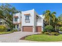 Beautiful two-story home with a well-manicured lawn and a brick driveway leading up to the two car garage at 4911 W Melrose S Ave, Tampa, FL 33629