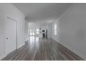 Open concept living room with wood-look tile flooring and neutral paint scheme at 5720 66Th N Ln, St Petersburg, FL 33709