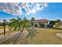 Charming home with landscaped front yard, featuring palm trees and decorative rock gardens under a sunny sky at 701 Baltusrol Way, Sun City Center, FL 33573