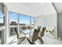 Modern dining room featuring a glass table, designer chairs, and expansive windows with waterfront views at 851 Bayway Blvd # 904, Clearwater Beach, FL 33767