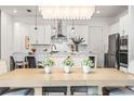 Bright dining area showcasing a modern kitchen with stainless steel appliances and elegant lighting at 8721 Drummer Plank Dr, Wesley Chapel, FL 33545