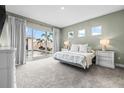 Serene bedroom featuring carpet floors, natural light, and private access to the outdoor pool area at 8721 Drummer Plank Dr, Wesley Chapel, FL 33545