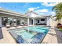 Inviting backyard pool and spa surrounded by outdoor seating and mature landscaping, perfect for relaxation at 8721 Drummer Plank Dr, Wesley Chapel, FL 33545