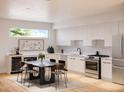 Modern kitchen features sleek white cabinets, stainless steel appliances, and a stylish dining area at 879 6Th S Ave, St Petersburg, FL 33701