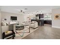 Bright and airy living room with tile floors, ceiling fan, and an open floorplan to the kitchen and dining areas at 1180 Eden Isle Ne Blvd, St Petersburg, FL 33704
