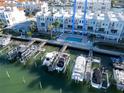 Aerial view of luxury waterfront townhomes featuring private boat docks and a community pool at 130 Brightwater Dr # 5, Clearwater Beach, FL 33767