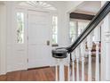 Welcoming foyer with hardwood floors, white wainscoting, and natural light from the front door at 2514 W Morrison Ave, Tampa, FL 33629
