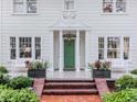 A close up of the front of the home showcasing the entry door, columns, and landscaping at 2514 W Morrison Ave, Tampa, FL 33629