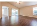 Bright living room featuring vaulted ceilings, dark hardwood floors, and a sliding glass door at 29636 Tee Shot Dr, San Antonio, FL 33576