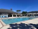 Community pool with ample seating, a covered pavilion, and clear blue water on a sunny day at 30045 Southwell Ln, Wesley Chapel, FL 33543