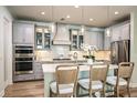 Elegant kitchen showcasing grey cabinetry, stainless steel appliances, and pendant lighting at 3915 Farm Garden Ct, Lakewood Ranch, FL 34211