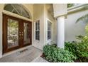 Inviting front entryway with a wood door, brick walkway, and decorative landscaping, creating a warm welcome at 4324 Auston Way, Palm Harbor, FL 34685