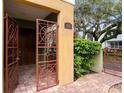 Inviting courtyard entrance featuring decorative metal gates, stone pavers, and lush greenery at 4907 Bayshore Blvd # 115, Tampa, FL 33611