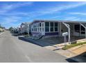 Mobile home displaying a bright sunroom and well-maintained landscaping, set on a quiet street at 79 Yawl Ln # 79, Palm Harbor, FL 34683