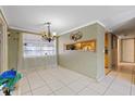 Traditional dining room with tile flooring, large window, unique light fixture and access to kitchen at 8343 Galewood Cir, Tampa, FL 33615
