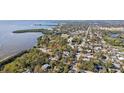 Scenic aerial view of neighborhood near the water featuring lush landscaping, beautiful homes, and water views at 1015 Coldstream Ct, Tarpon Springs, FL 34689