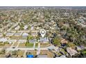 Wide aerial view of a suburban neighborhood featuring tree-lined streets, various homes, and a location pin at 1015 Coldstream Ct, Tarpon Springs, FL 34689
