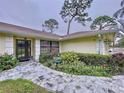 Inviting front entrance with landscaped garden beds and stone walkway leading to the front door at 1309 Hillside Dr, Tarpon Springs, FL 34689