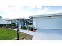 Exterior view of the home with a white garage door, well-maintained lawn, and inviting curb appeal at 1320 Bottlebrush Dr, Bradenton, FL 34208