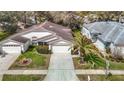 Aerial view of a single-story home with a well-maintained lawn, driveway, and mature landscaping at 13439 Norman Cir, Hudson, FL 34669