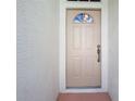 Close-up view of a front door with detailed trim and a decorative window above at 13439 Norman Cir, Hudson, FL 34669