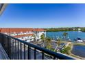 Scenic building exterior with red roof, waterfront views, parking, and lush tropical palm trees at 19111 Vista Bay Dr # 401, Indian Shores, FL 33785