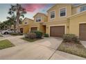 Sunny view of several townhomes, showcasing the well-kept landscaping, driveways, and architectural details at 2007 Hawks View Dr, Ruskin, FL 33570
