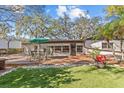 This backyard has a wood deck with an outdoor table set on top of it and beautiful landscaping to enjoy the weather at 2207 Boxwood Way, Brandon, FL 33511