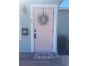 Close-up of a charming pink front door with a decorative wreath and a 'Welcome' mat at 2235 20Th St S, St Petersburg, FL 33712