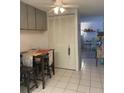 Cozy kitchen area featuring tiled floors, light-colored cabinets, and a dining table at 2700 Bayshore Blvd # 2308, Dunedin, FL 34698