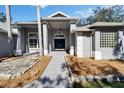 Inviting front entrance features a covered portico with decorative stone accents and a blue double door at 3904 Executive Cir, Plant City, FL 33566