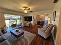 A cozy living room with hardwood floors, ceiling fan, and a sliding glass door to the balcony at 3934 37Th S St # 36, St Petersburg, FL 33711
