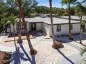 Aesthetic home exterior showing a landscaped front yard with palm trees, a deck, and a modern entryway at 3934 Huntington Ne St, St Petersburg, FL 33703