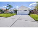 Exterior view showcasing a spacious driveway leading to a two-car garage with a manicured lawn at 4313 Brooke Dr, Valrico, FL 33594