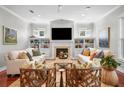 Cozy living room with a fireplace, built-in bookshelves, and large windows for natural light at 4603 S Bartlett St, Tampa, FL 33611