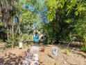 Exterior view of a charming yellow home and pathway, partially obscured by trees at 5029 29Th S Ave, Gulfport, FL 33707