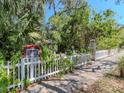 Inviting white picket fence and gate adorned with lush greenery and a Little Free Library at 5029 29Th S Ave, Gulfport, FL 33707