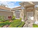 Inviting front entrance with manicured garden and lots of natural light at 726 Hidden Lake Dr, Tarpon Springs, FL 34689
