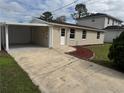 View of home with a large driveway and covered carport enhancing the curb appeal at 7909 N Packwood Ave, Tampa, FL 33604