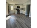Well-lit kitchen with gray vinyl floors, stainless steel appliances, and white cabinets at 7909 N Packwood Ave, Tampa, FL 33604