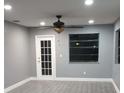 Living room with neutral gray paint, wood-look flooring, ceiling fan, and a back door at 10367 Councils Way, Temple Terrace, FL 33617
