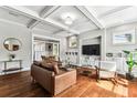 Bright living room with coffered ceilings, hardwood floors, built-in shelving, and modern furniture at 1214 E Hanna Ave, Tampa, FL 33604